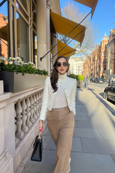 a lady wears a beige cropped tweed jacket with camel pants